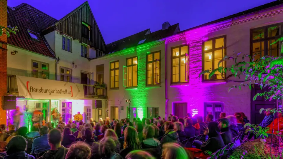 Historischer Kaufmannshof in Flensburgs Altstadt mit Kopfsteinpflaster, Backsteinspeichern und Fachwerkhäusern