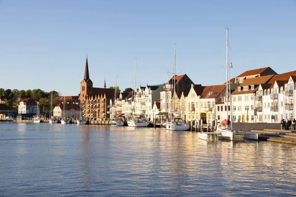 Day trip to Denmark — colourful harbour houses and red lighthouse on the Danish coast