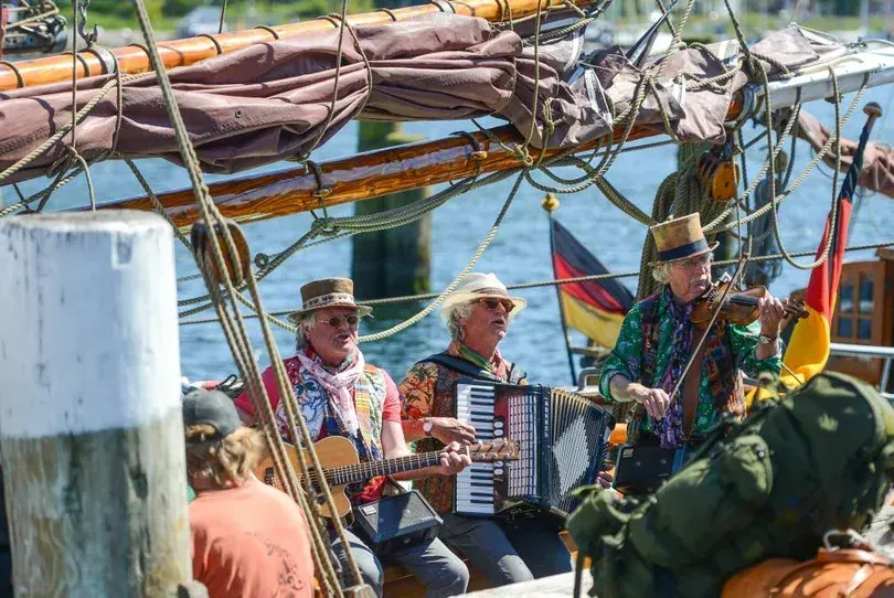 Segelboote bei der Rum-Regatta im Flensburger Hafen mit Zuschauern am Kai