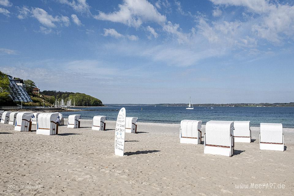 Strandkörbe am Ufer der Flensburger Förde in Glücksburg bei blauem Himmel