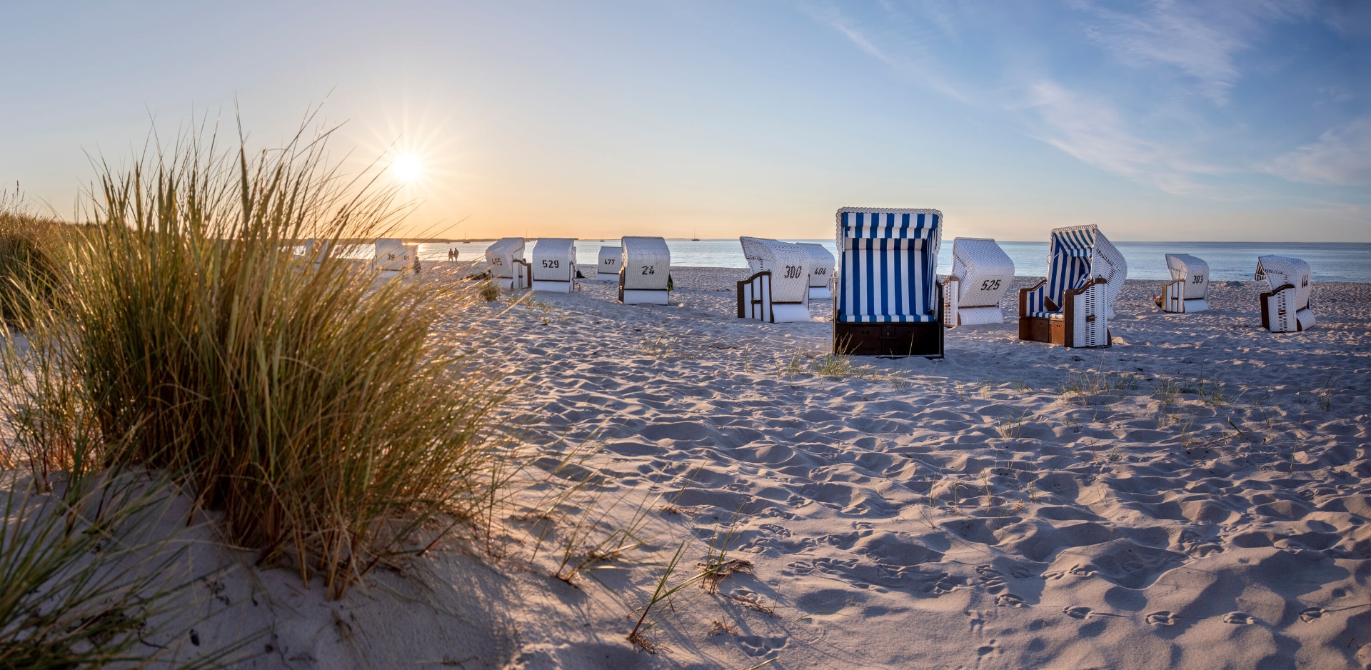 Strandkörbe im goldenen Sonnenuntergang an der Ostsee — Dünen und Meer